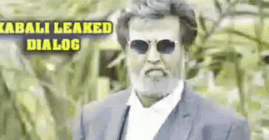 a man wearing sunglasses and a suit is standing in front of a sign that says kabali leaked dialog .