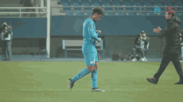 a soccer player in a blue uniform with the word om on the back
