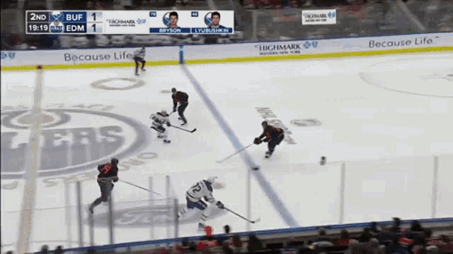 a hockey game is being played in front of a because life banner