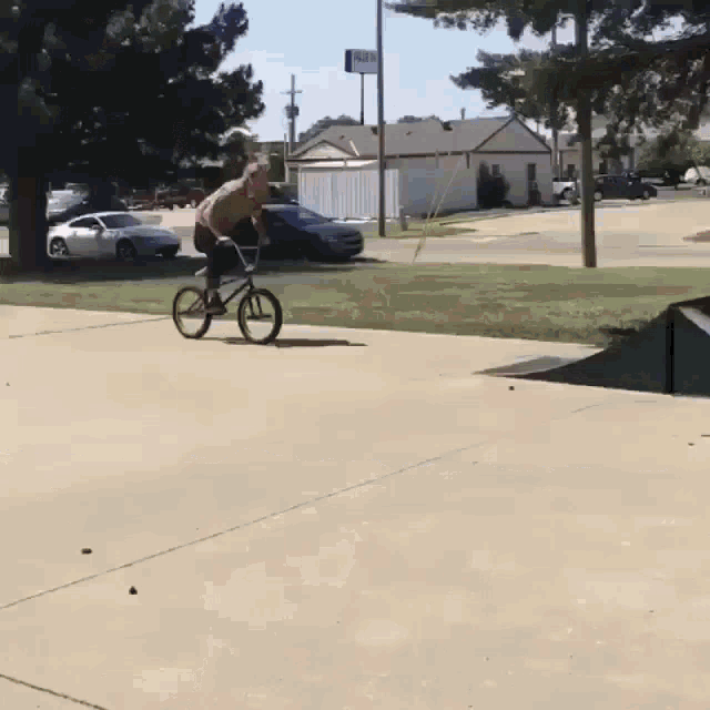 a person riding a bike on a sidewalk in front of a sign that says ' a & m ' on it