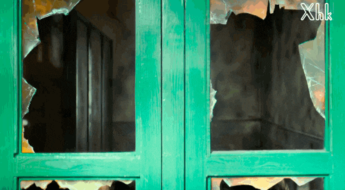 a green door with a broken glass and the letters xhk on the bottom