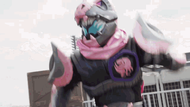 a robot with a pink helmet is standing in front of a building in a city .