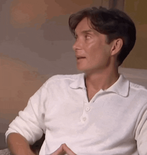 a man in a white polo shirt is sitting down