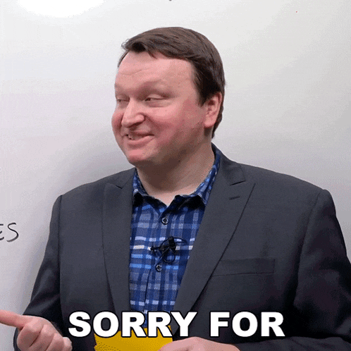 a man in a suit says sorry for in front of a whiteboard