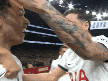 a man with a tattoo on his arm wears a white jersey that says cats