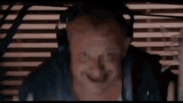 a man wearing headphones is looking out of a window .
