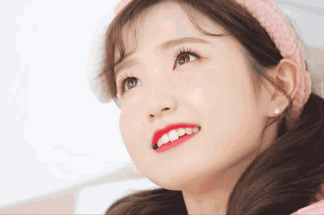 a close up of a girl 's face with a pink headband on