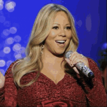 a woman in a red dress is singing into a microphone on a stage .
