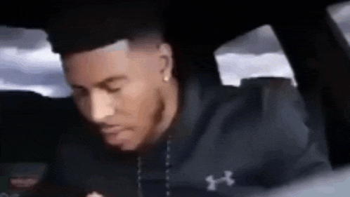a man is sitting in the back seat of a car .