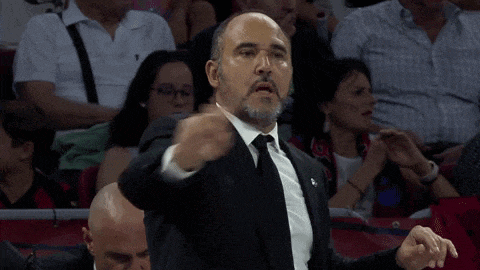 a man in a suit and tie giving a thumbs up
