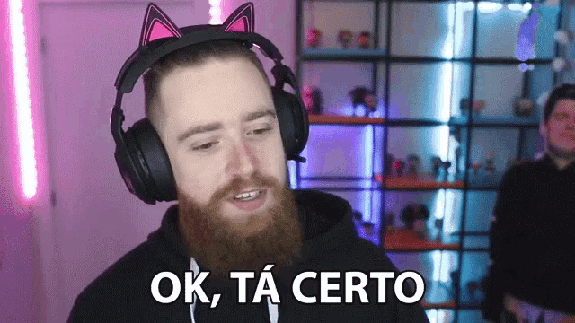 a man with a beard wearing headphones with cat ears says ok ta certo