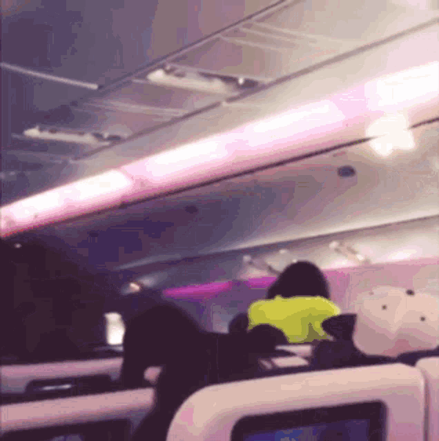 a woman in a yellow jacket sits in a plane