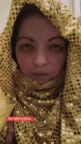 a woman wearing a yellow scarf with the words pov nikki is hiding underneath
