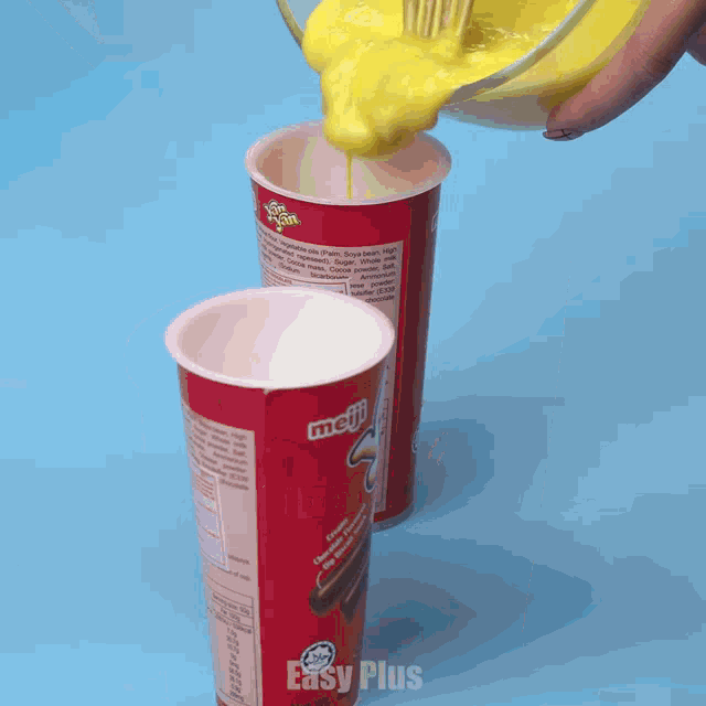 a person is pouring a yellow liquid into a cup that says easy plus