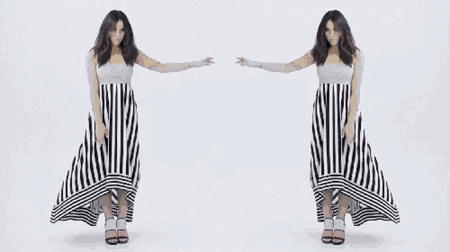 a woman in a black and white striped dress is standing in front of a white background