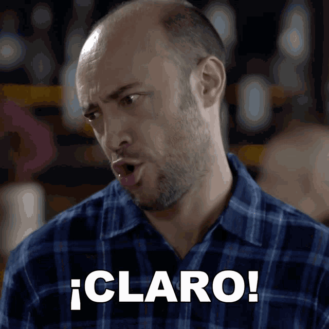 a man wearing a plaid shirt says claro in white letters