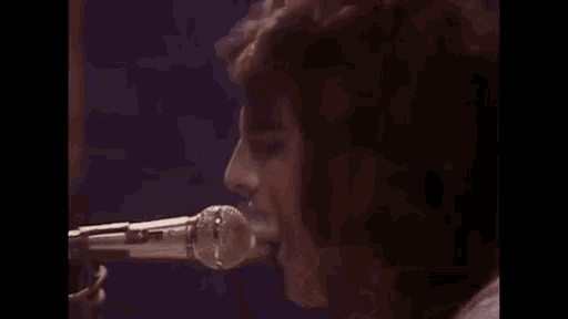 a woman is singing into a microphone on stage .