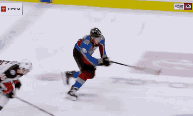 a hockey game is being played in front of an ad for toyota