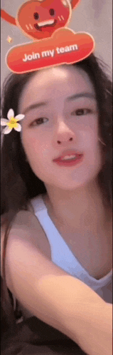 a woman wearing a white tank top with a flower in her hair and a sign on her head that says join my team .