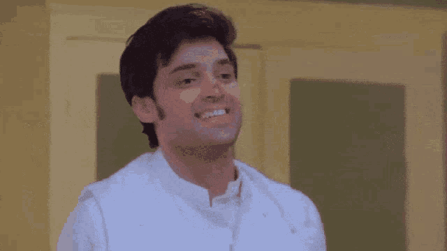 a man in a white shirt is smiling and looking up