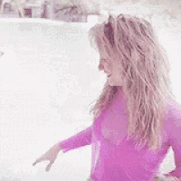 a woman in a purple shirt is standing in front of a pool .