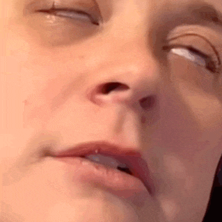 a close up of a woman 's face with her eyes closed and mouth open .