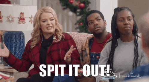 a group of people are sitting on a couch and one of them says spit it out .