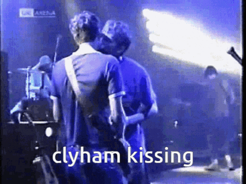 two men kissing on a stage with the words clyham kissing in the corner