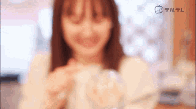 a blurry picture of a woman with a tv on the bottom right corner