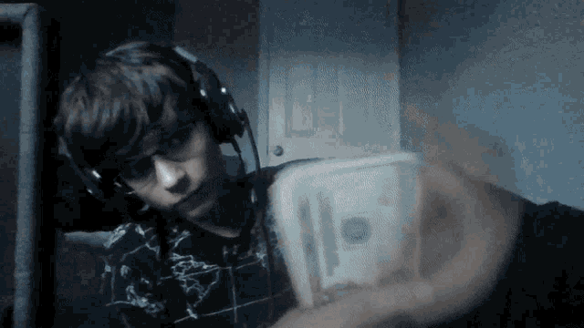 a boy wearing headphones holds a stack of money in his hand