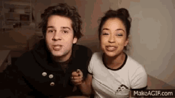 a man and a woman are sitting next to each other on a bed .
