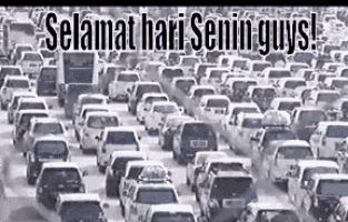 a bunch of cars are driving down a street in a busy city .