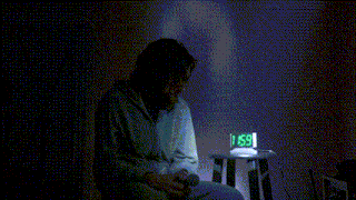 a man is sitting in front of a digital clock that says 12:00