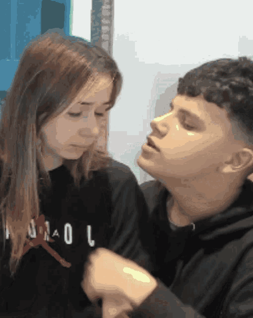 a boy and a girl are looking at each other and the girl is wearing a hoodie that says air jordan