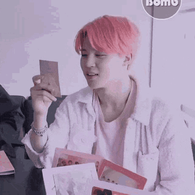 a person with pink hair is holding a piece of paper that says bomb