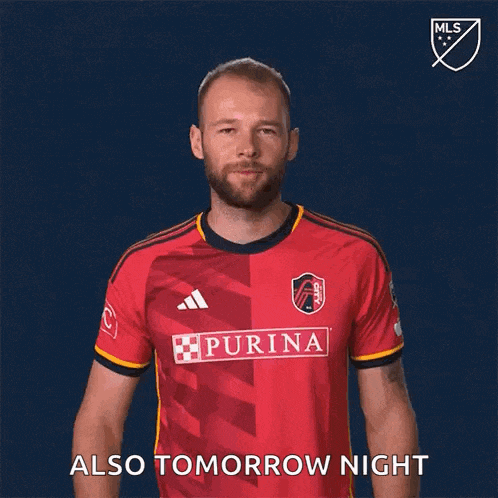 a man wearing a red purina jersey is making a gesture that says also tomorrow night