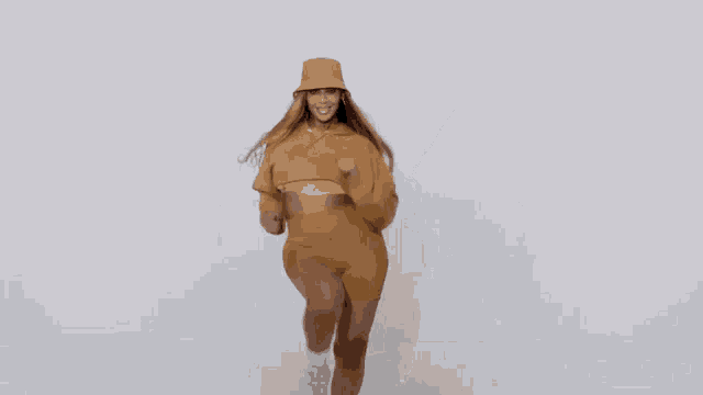 a woman in a hoodie and shorts is dancing in front of a white background .