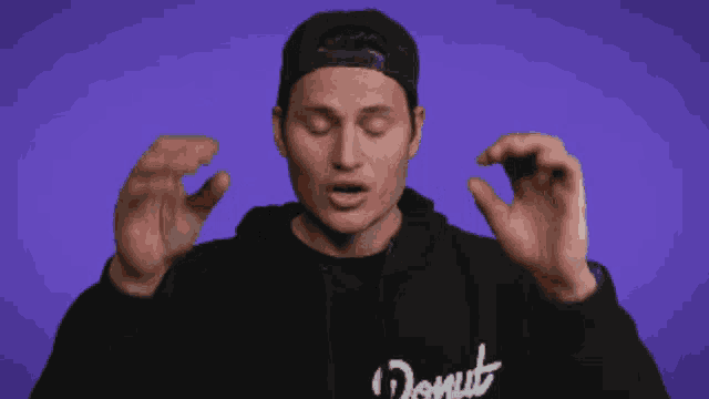 a man wearing a donut hoodie is making a funny face