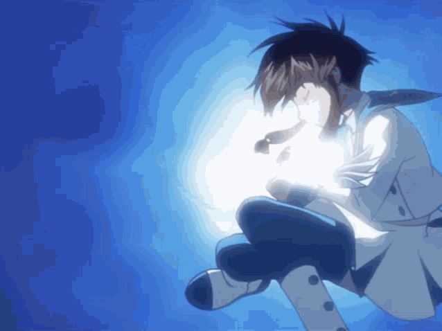 a boy in a white suit and tie is holding a light