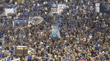 a crowd of people in a stadium with a scoreboard that says 14:44