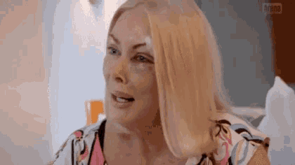 a woman with a black eye and a bruise on her face is sitting in a hospital bed .