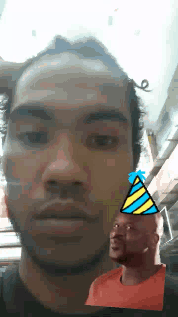 a man wearing a party hat looks at another man