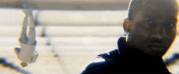a close up of a man 's face with a reflection of a person in the background