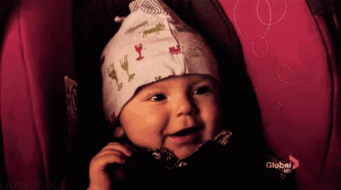 a baby wearing a hat is sitting in a car seat that says global nbc