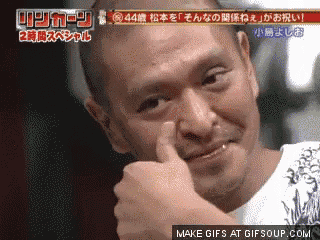 a man with a shaved head is giving a thumbs up in a foreign language
