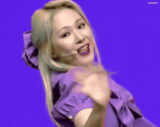 a woman in a purple dress is dancing in front of a strawberry and watermelon .
