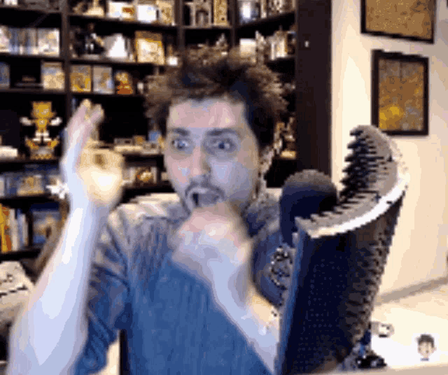 a man is sitting in front of a shelf with a lot of toys