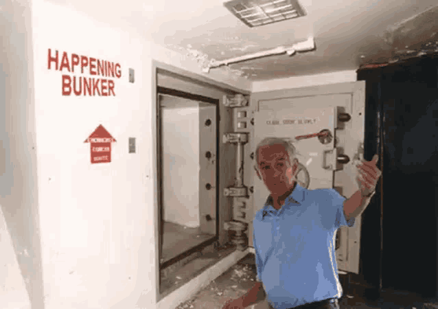 a man is standing in a room with a sign that says happening bunker on the wall