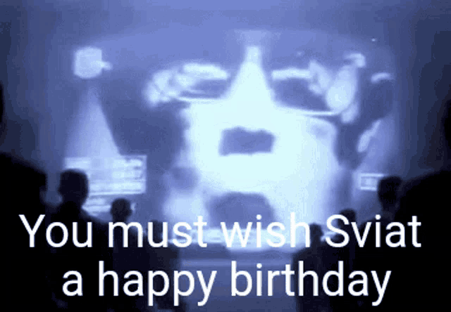 a group of people looking at a screen that says you must wish swiat a happy birthday