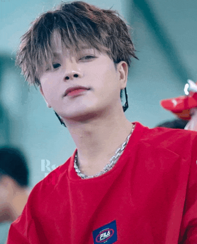 a close up of a person wearing a red fila t-shirt